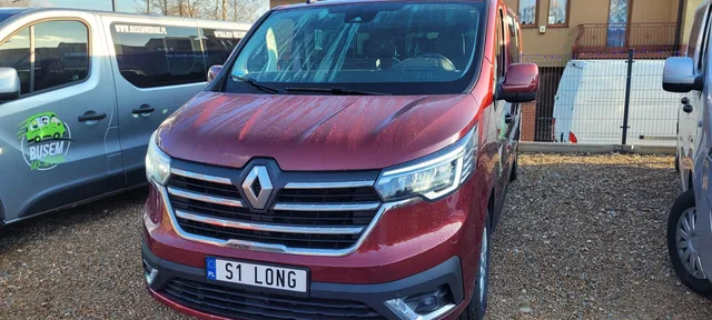 Czerwony Renault Trafic na placu
